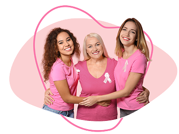 Three women smiling in breast cancer awareness shirts 